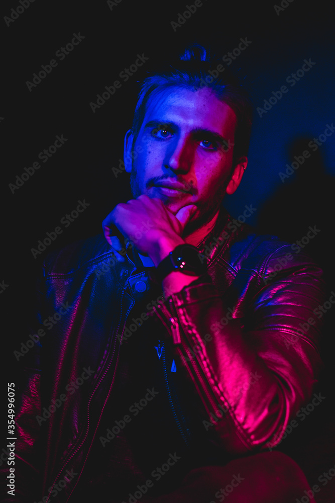 Man in his 30s posing to the camera with blue and red lighting, close up portrait Man in his 30s posing to the camera with blue and red lighting, close up portrait