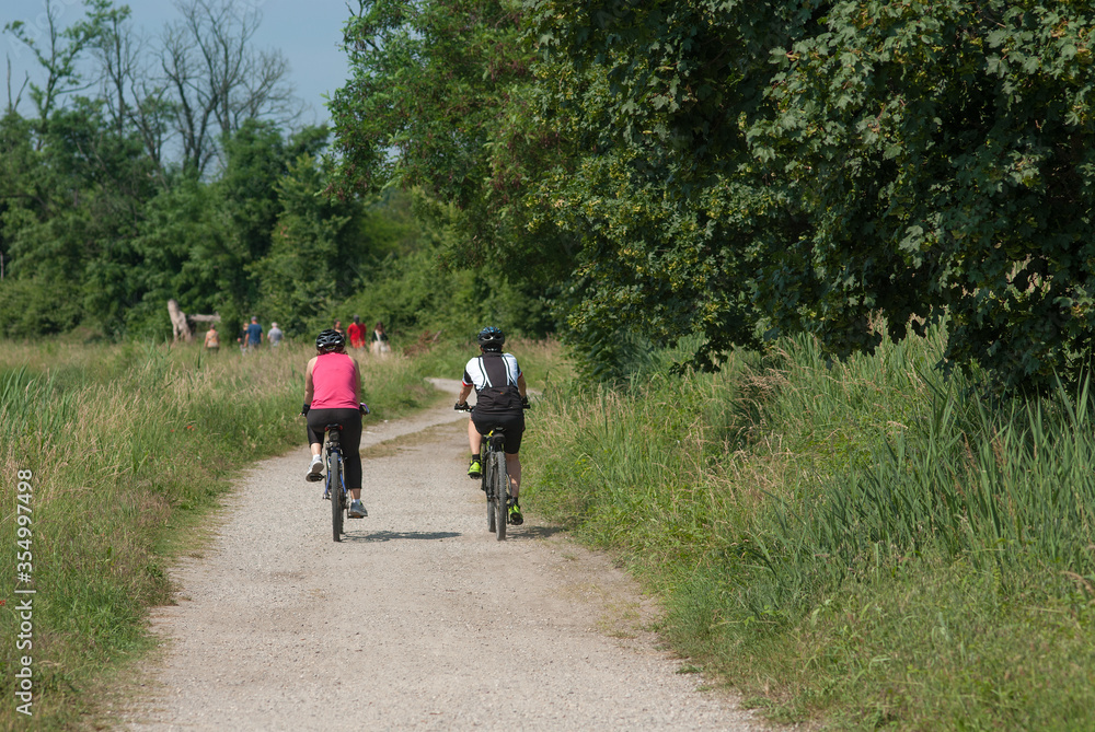 i ciclisti pedalano sulla strada sterrata di campagna i ciclisti pedalano sulla strada sterrata di campagna