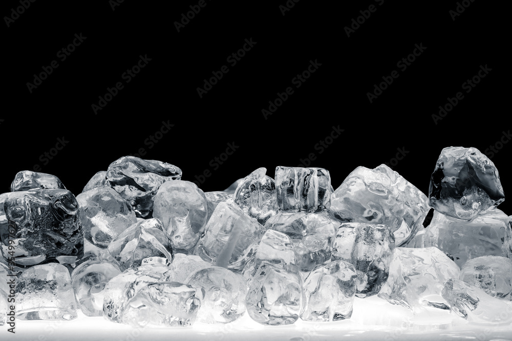 Pieces of natural crushed ice cubes on white surface on black background.