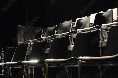 rangée de chaises de théâtre en plastique noir et à pieds métalliques et brillants photo