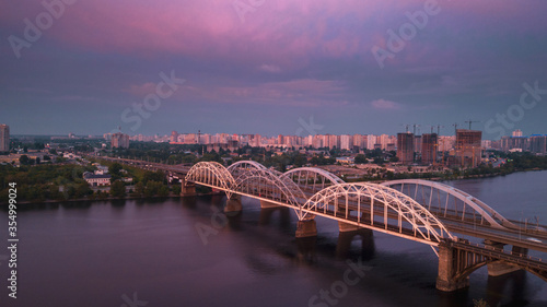 aerial city view, luminous buildings and bridge at sunset. Drone shot.