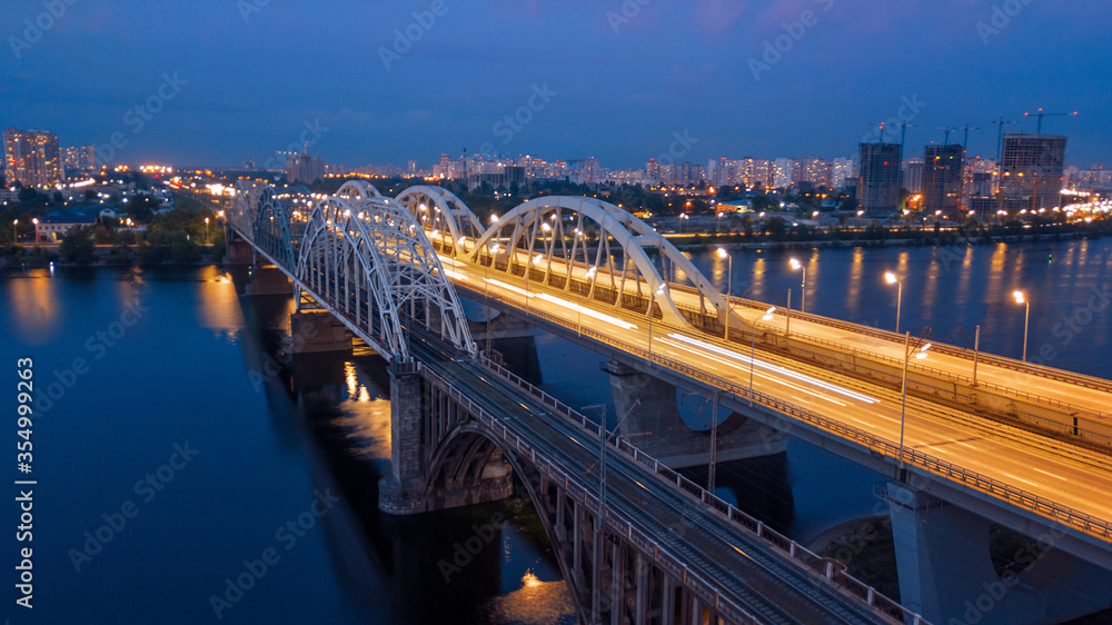 Obraz premium aerial night city view, luminous buildings and bridge. Drone shot.