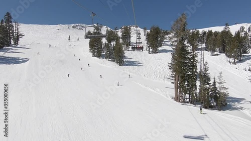 Many skiers and snowboarders going down a blue run in lake tahoe