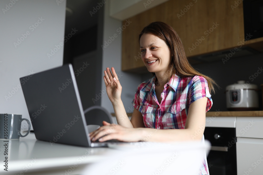 Housewife in kitchen talking via video conferencing Housewife in kitchen talking via video conferencing