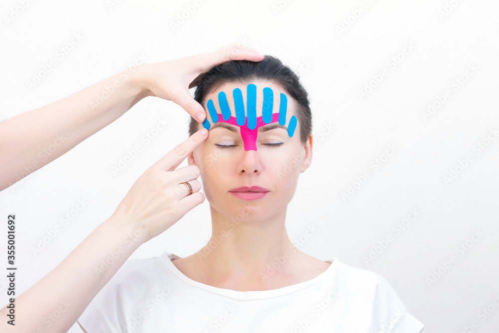Face taping, close-up of a girls face with cosmetological anti-wrinkle tape. Face aesthetic taping. Non-invasive anti-aging lifting method for reduction of wrinkles Face taping, close-up of a girls face with cosmetological anti-wrinkle tape. Face aesthetic taping. Non-invasive anti-aging lifting method for reduction of wrinkles