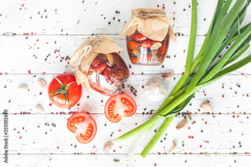 Sun dried tomato top view. Flat lay shot of jar with homemade conservation. Preserve with tomatoes. Italian spices for pizza. photo