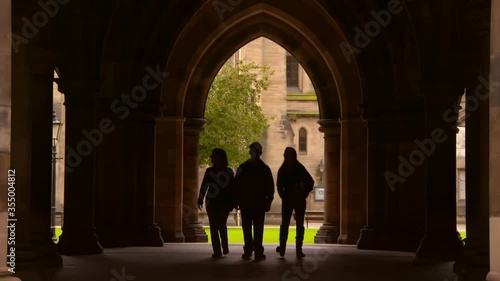 Lockdown shot of silhouette people walking in public university archway - Glasgow, Scotland photo