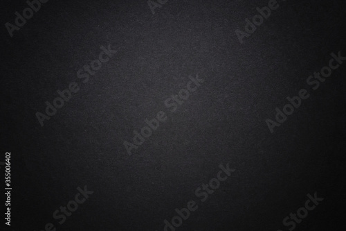 Black dark background with light copyspace in middle. Toned grunge retro vintage wallpaper with cardboard texture surface. Mockup design for dark arts. Blackout Tuesday concept. Black lives matter.