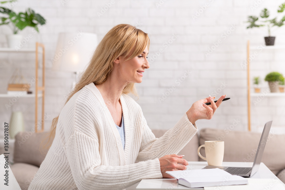 Remote work. Woman with pen in hands looks at laptop and asks question Remote work. Woman with pen in hands looks at laptop and asks question