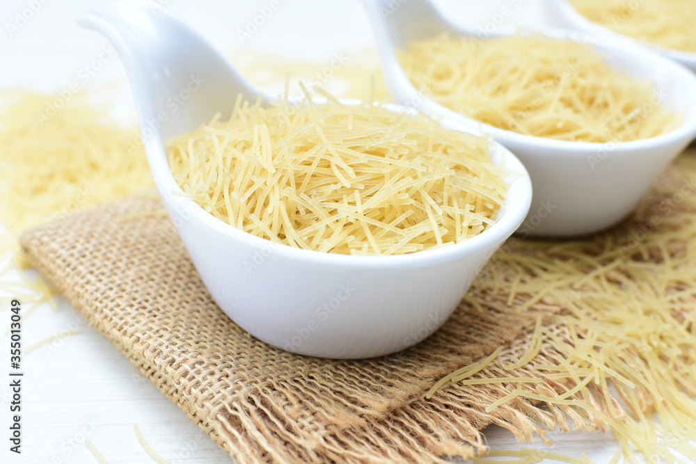 Short pasta spaghetti angel hair displayed in containers on white background Short pasta spaghetti angel hair displayed in containers on white background