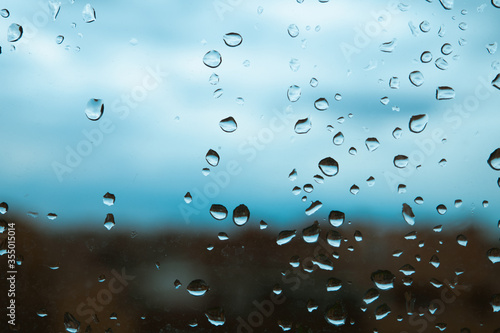 Gotas de lluvia sobre el cristal de una ventana en un día nublado.