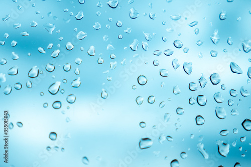 Gotas de lluvia sobre el cristal de una ventana en un día nublado.