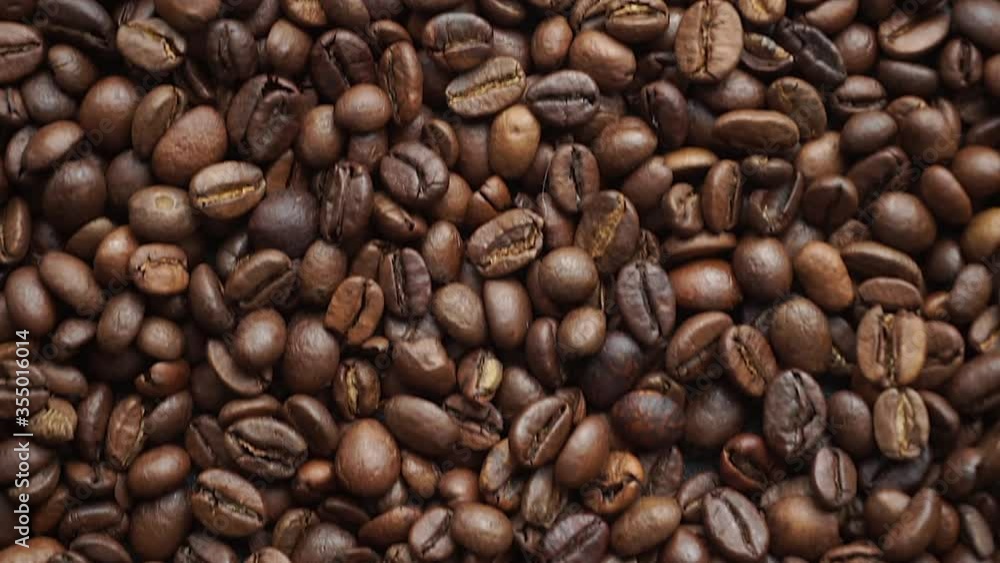 Coffee beans background. Making and roasting coffee beans for a drink. Slow mo top view Coffee beans background. Making and roasting coffee beans for a drink. Slow mo top view
