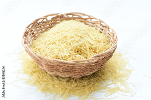 Short pasta spaghetti angel hair displayed in containers on white background
