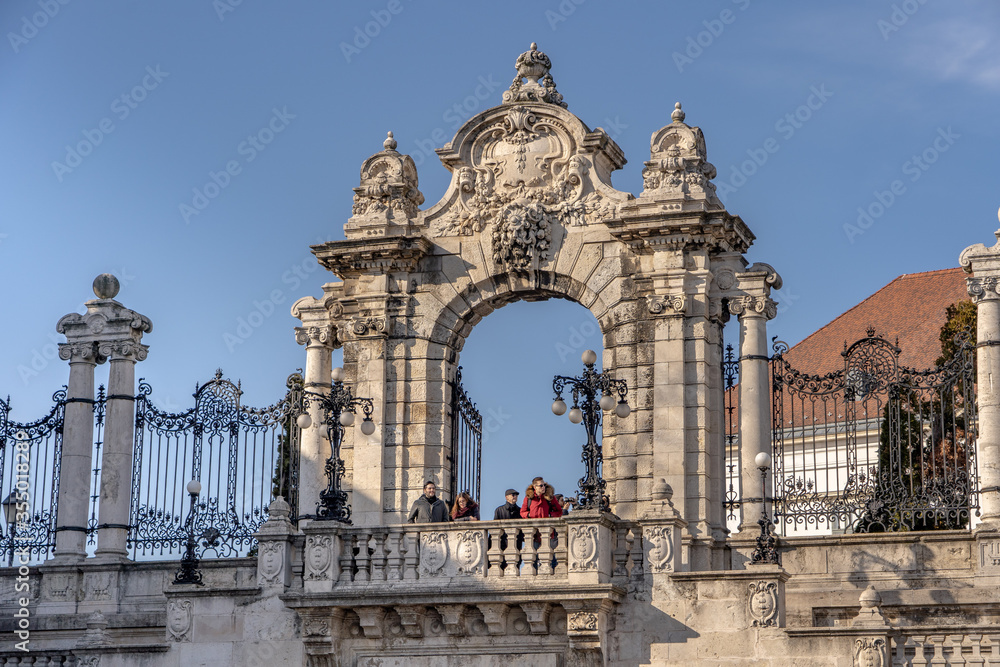 Budapest, Hungary - Feb 9, 2020: Tourists at stairs of gate of Sandor Palace at Buda Castle