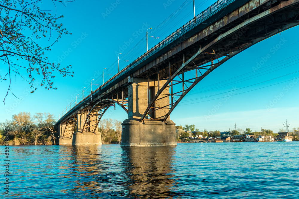 Fototapeta premium Arched bridge over the river. Concrete and metal construction
