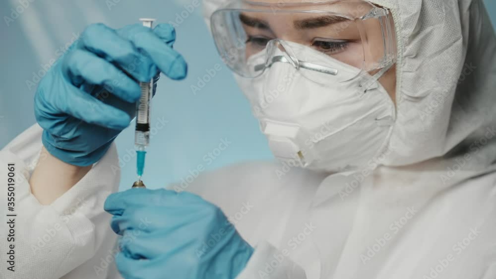 Doctor hold a syringe and pick up vaccine against coronavirus at the hospital. Treatment in clinic. Science research about pandemic. Performing cinical test in laboratory. Quarantine, covid-19 concept Doctor hold a syringe and pick up vaccine against coronavirus at the hospital. Treatment in clinic. Science research about pandemic. Performing cinical test in laboratory. Quarantine, covid-19 concept