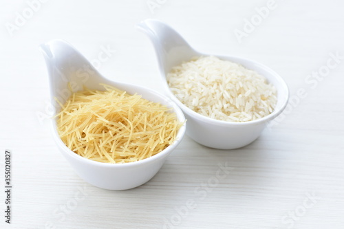 Obraz na płótnie Short pasta spaghetti angel hair and uncooked rice displayed in containers on white background w salonie