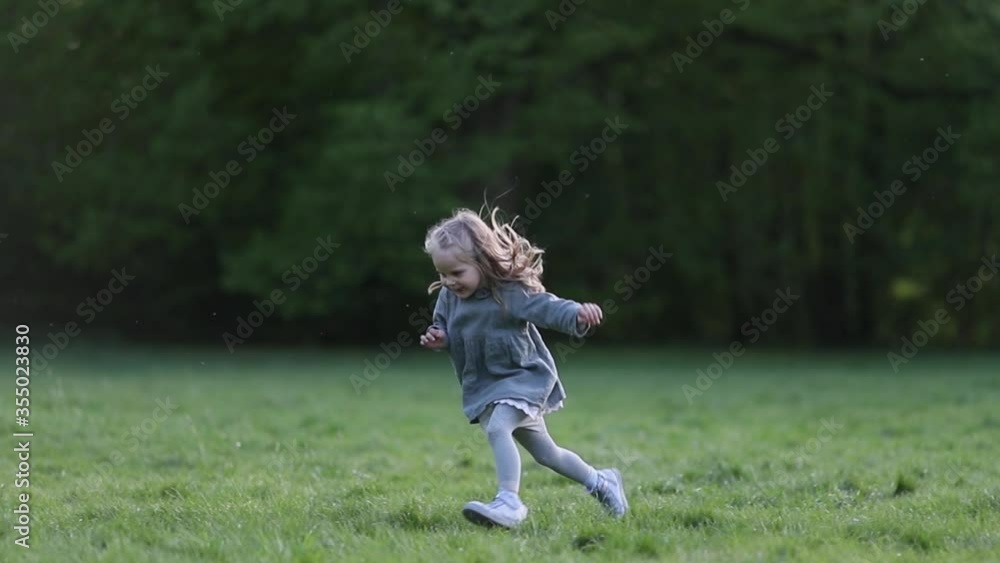 A little blond girl running in slow motion in grey, slow motion A little blond girl running in slow motion in grey, slow motion