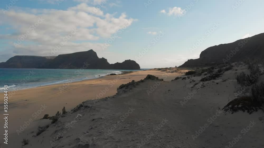 Aerial low angle through Beach dunes over Island Landscape Background Aerial low angle through Beach dunes over Island Landscape Background