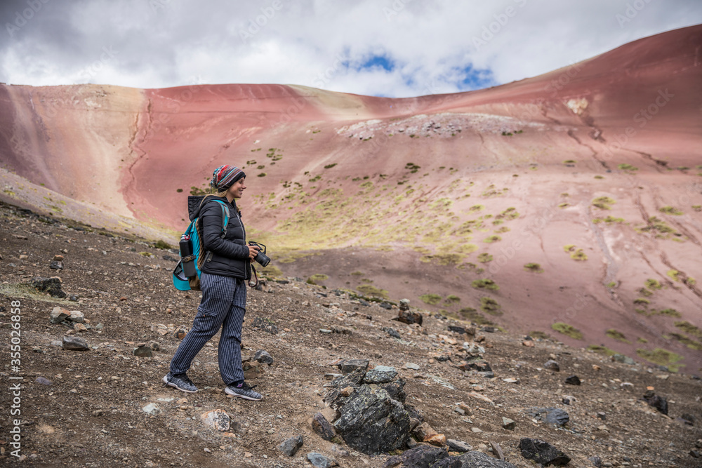 blonde woman hiking in the 7 color mountain in peru. 7 color mountain.