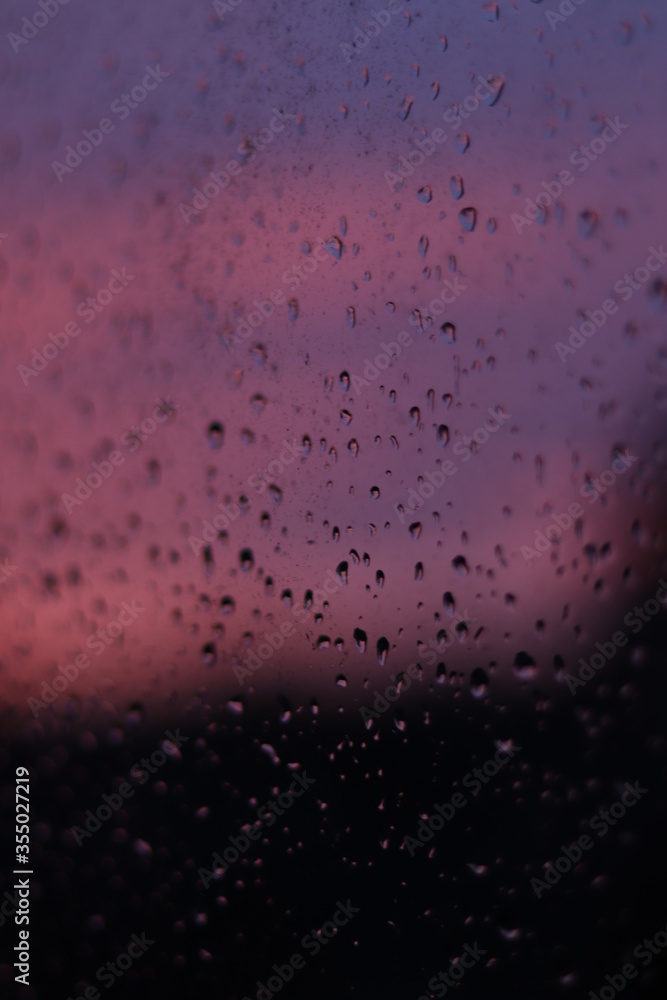 raindrops on window with sunset