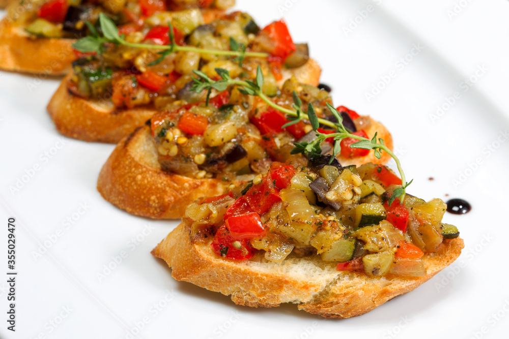 Bruschetta with stewed vegetables and Basil on fried garlic cheese bread. Selective focus. As backdrop for menus, cookbooks, advertisements and other culinary projects Bruschetta with stewed vegetables and Basil on fried garlic cheese bread. Selective focus. As backdrop for menus, cookbooks, advertisements and other culinary projects