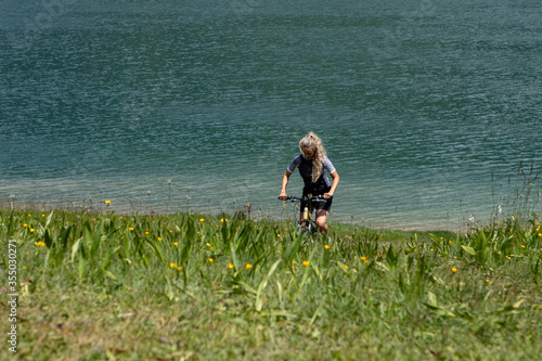Life style woman with long blond hair on mountain bike in Swiss