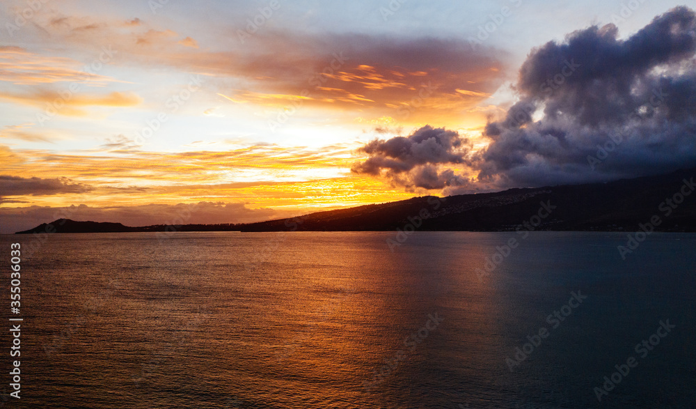 Aerial picture of beautiful firing sunset at Hawaii with ocean, palm trees and cliff Aerial picture of beautiful firing sunset at Hawaii with ocean, palm trees and cliff