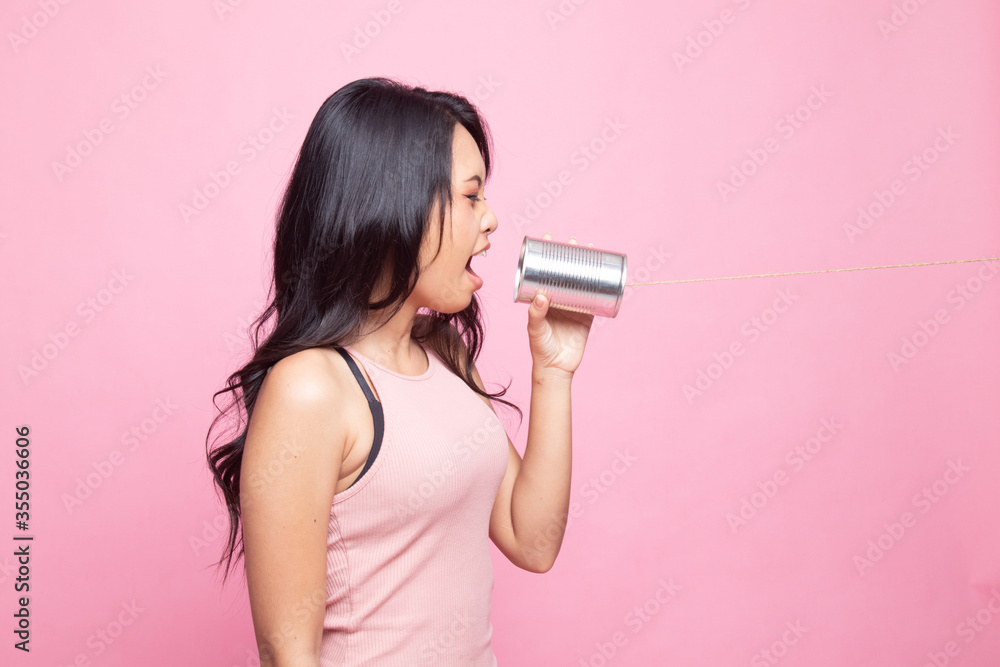 Young Asian woman shout with tin can phone. Young Asian woman shout with tin can phone.