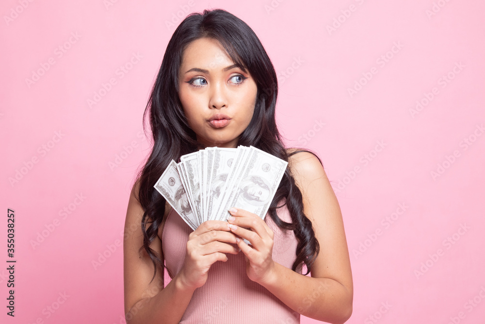 Φωτογραφία Portrait of  young asian woman  showing bunch of money banknotes.