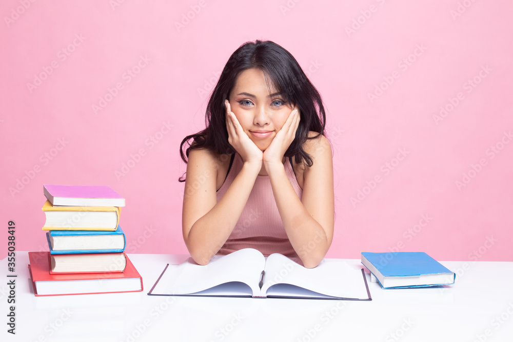 Young Asian woman read a book with books on table. Young Asian woman read a book with books on table.