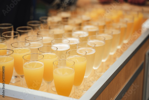 Rows of glasses with various colorful drinks standing on buffet table. Celebration, birthday, party, wedding concept.