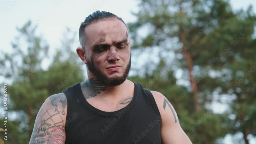Man sharpening wooden shavings with a knife on nature and throwing them down
