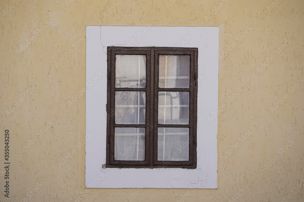 Old brown wooden window with yellow background