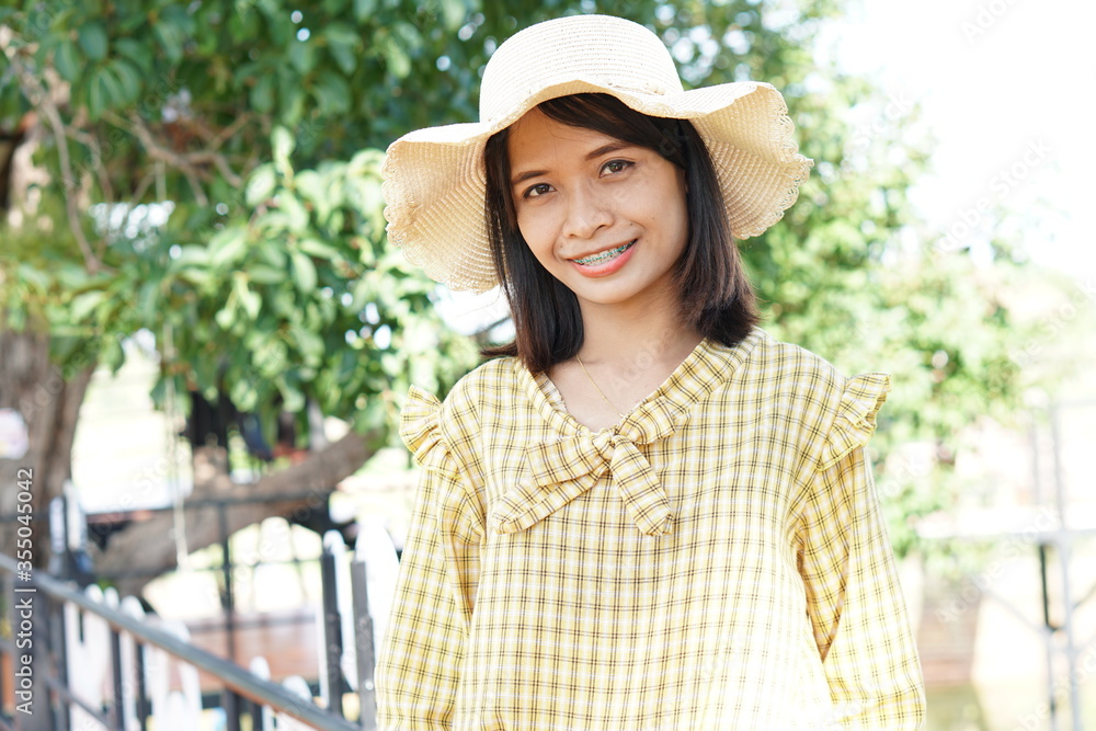 portrait Asian woman wearing yellow dress, happy to travel, smiling, seeing braces