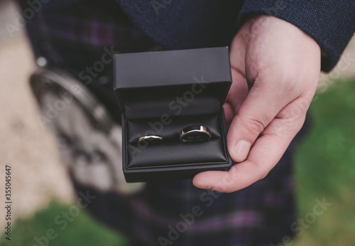 Man/groom holds 2 wedding rings in box