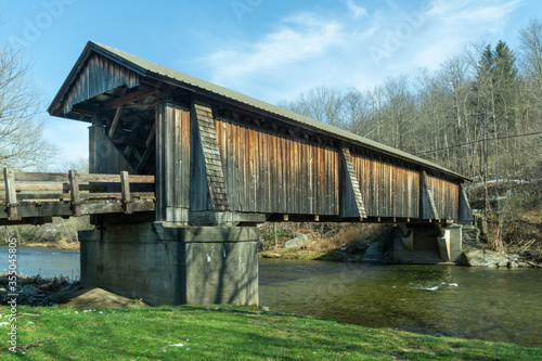 Livingston Manor, NY / United States - April 19, 2020: A three-quarter view of the Livingston Manor Covered Bridge spanning the scenic Willowemoc Creek