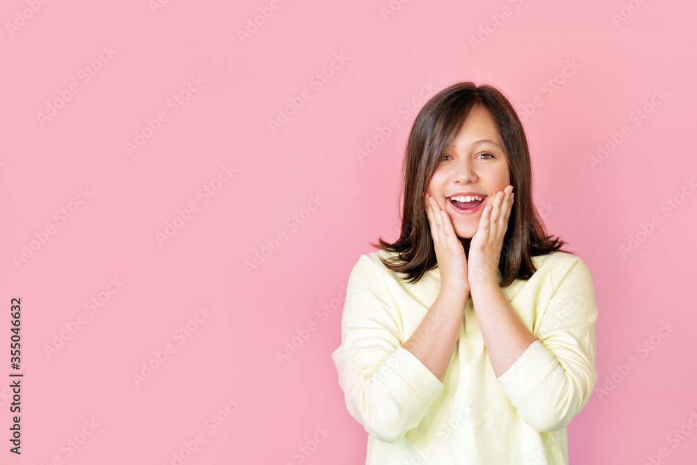 Teenage girl smiles against pink background. Teenage girl smiles against pink background.