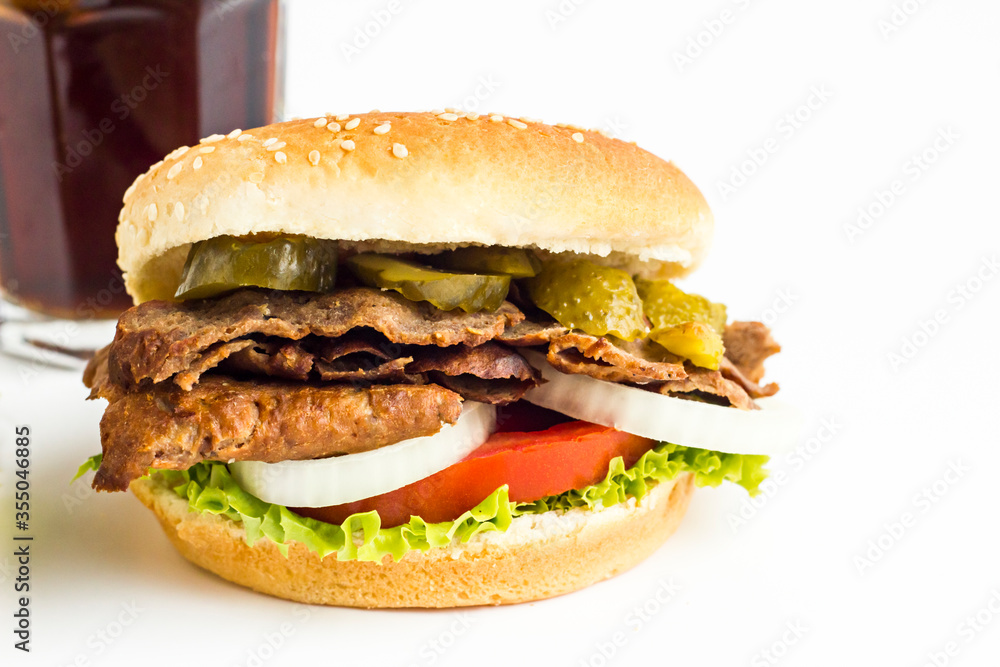 Delicious Burger made with Traditional Turkish Doner Kebab,tomato,pickle,lettuce and onion rings on the white background with cold drink. Delicious Burger made with Traditional Turkish Doner Kebab,tomato,pickle,lettuce and onion rings on the white background with cold drink.