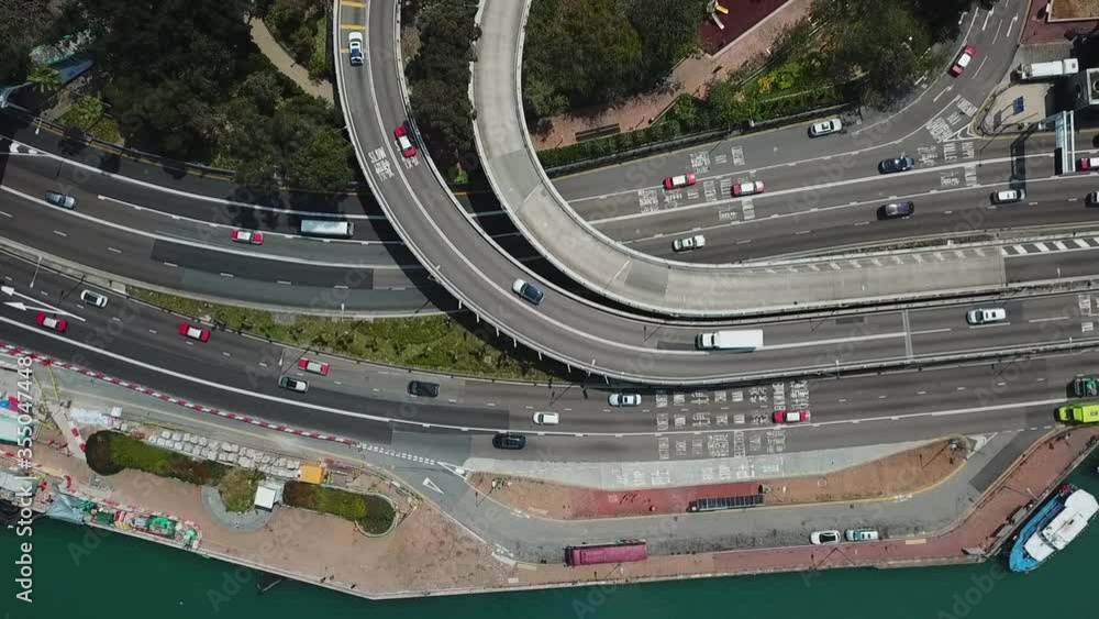 Aerial top view of vehicles on street and overpass in city, drone ascending over roads on sunny day - Hong Kong, China Aerial top view of vehicles on street and overpass in city, drone ascending over roads on sunny day - Hong Kong, China