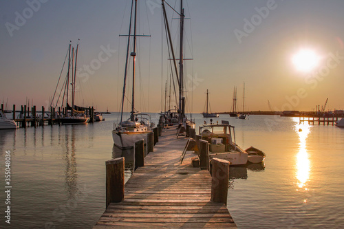 Obraz na płótnie Marthas Vineyard, MA / United States-May 29, 2016: Sail boat and motor boat tied to the dock Martha's Vineyard w salonie