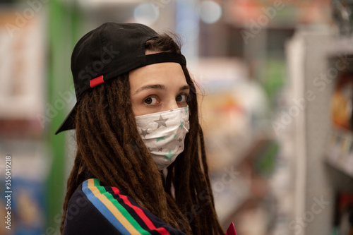 girl wears a handmade mask made of fabric to protect against coronavirus infection © Евгений Вдовин