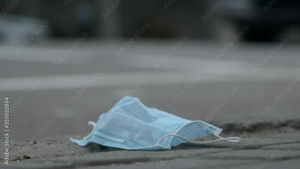 Time-lapse, discarded medical face mask lies on the sidewalk, on the background walks birds, peoples and cars drive. Face masks polluting streets of the city since Coronavirus COVID-19. Soft focus.
Time-lapse, discarded medical face mask lies on the sidewalk, on the background walks birds, peoples and cars drive. Face masks polluting streets of the city since Coronavirus COVID-19. Soft focus.