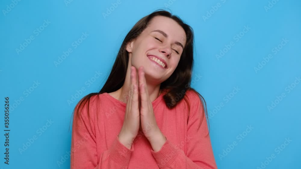 Amazed joyful young brunette woman spreads palms, being excited by good news, has toothy smile, dressed in red sweater, isolated over blue studio background. People, emotions and feelings concept Amazed joyful young brunette woman spreads palms, being excited by good news, has toothy smile, dressed in red sweater, isolated over blue studio background. People, emotions and feelings concept