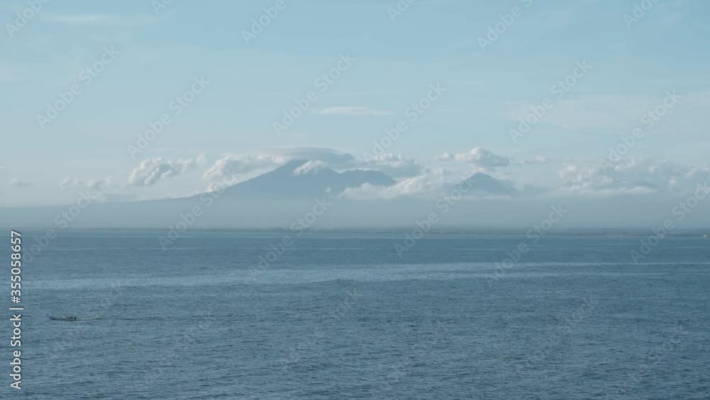 Marine landscape with blue clear water, clouds and volcanoes on the horizon Marine landscape with blue clear water, clouds and volcanoes on the horizon