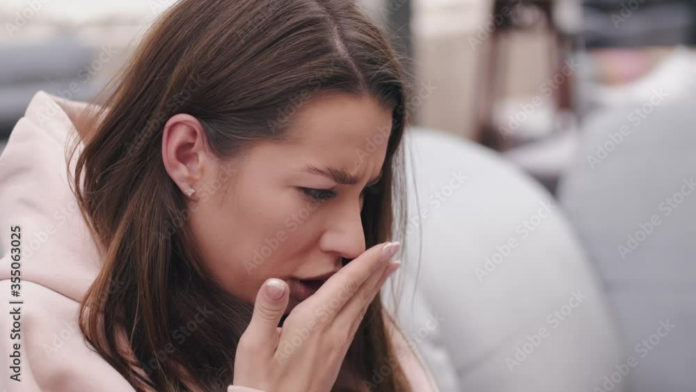 A sad woman is checking something in a laptop. She is sitting on a couch. A sad woman is checking something in a laptop. She is sitting on a couch.