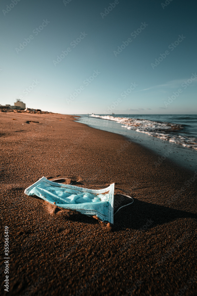 Conceptual scenery of a mask on the shore of the beach. Preserve and stay safe by Coronavirus Covid19. Quarantine is finished Conceptual scenery of a mask on the shore of the beach. Preserve and stay safe by Coronavirus Covid19. Quarantine is finished