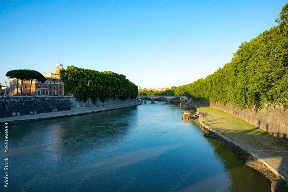 Tranquil evening view on the river Tiber in Rome with bridges in the shadow of sunset