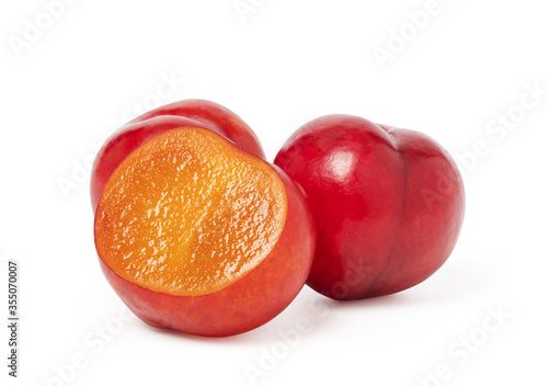 Ripe plum fruit cut half isolated on white background